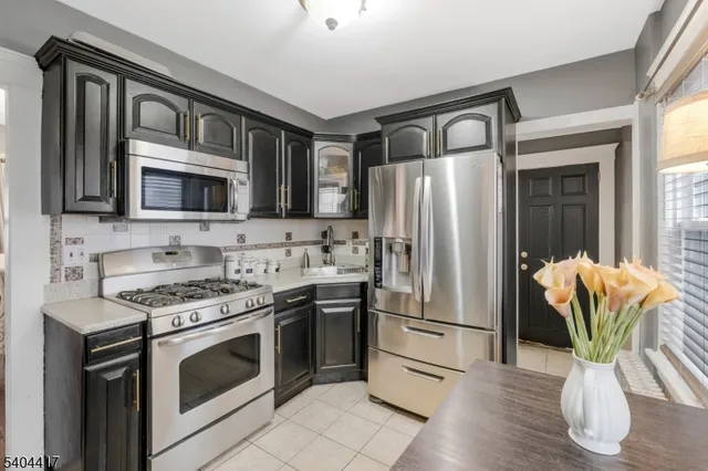 a kitchen with stainless steel appliances granite countertop a stove a refrigerator and a microwave