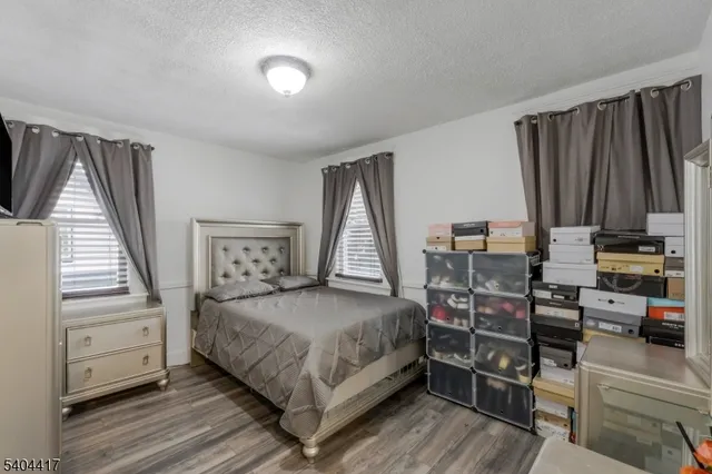 a bedroom with a bed and a flat tv screen on dresser
