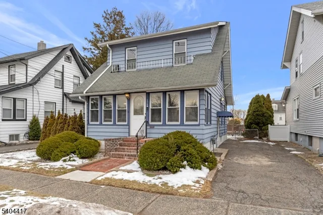 a front view of a house with a garden and outdoor seating