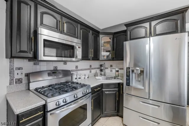 a kitchen with stainless steel appliances granite countertop a stove microwave and refrigerator