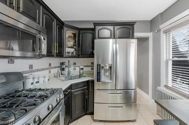 a kitchen with stainless steel appliances granite countertop a refrigerator and a stove