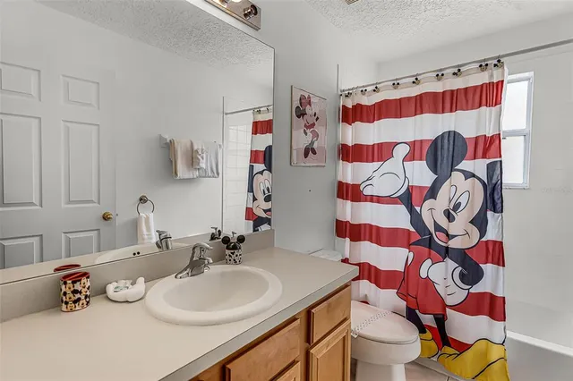 a bedroom with a bed and a mirror on dresser