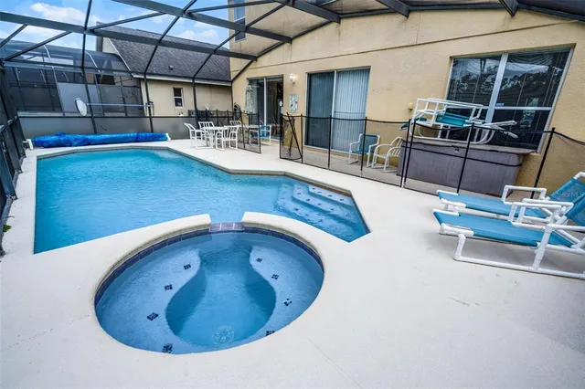 a view of a white house with a large window and potted plants