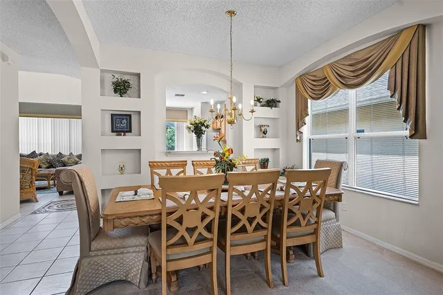 a view of a dining room and livingroom with furniture wooden floor a chandelier