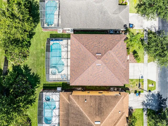an aerial view of residential houses with outdoor space and lake view