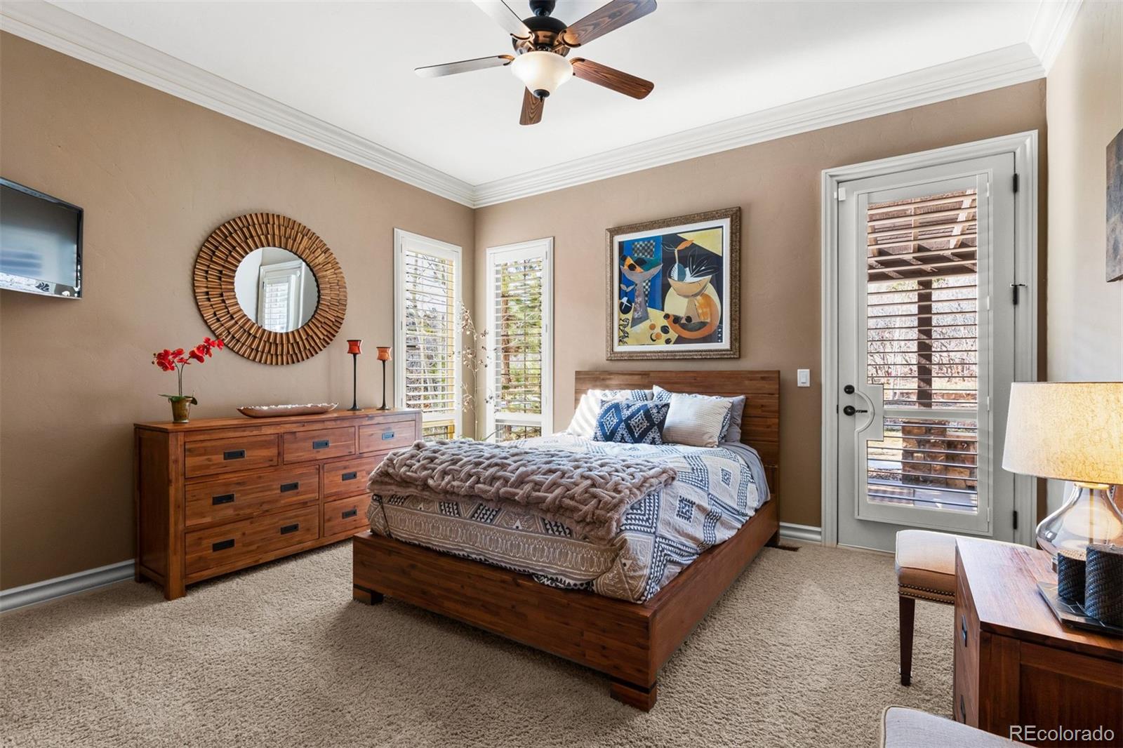 981 Buffalo Ridge Road Castle Pines, CO 80108 - Photo 11 of 39 a bedroom with a bed and a chandelier