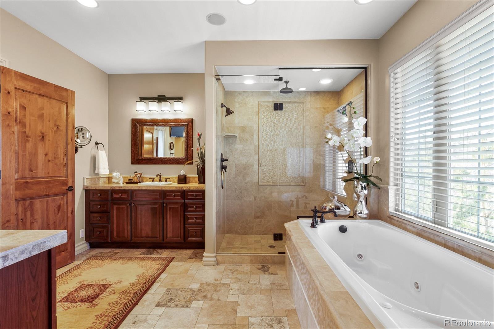981 Buffalo Ridge Road Castle Pines, CO 80108 - Photo 20 of 39 a large spacious bathroom with a tub sink shower and mirror