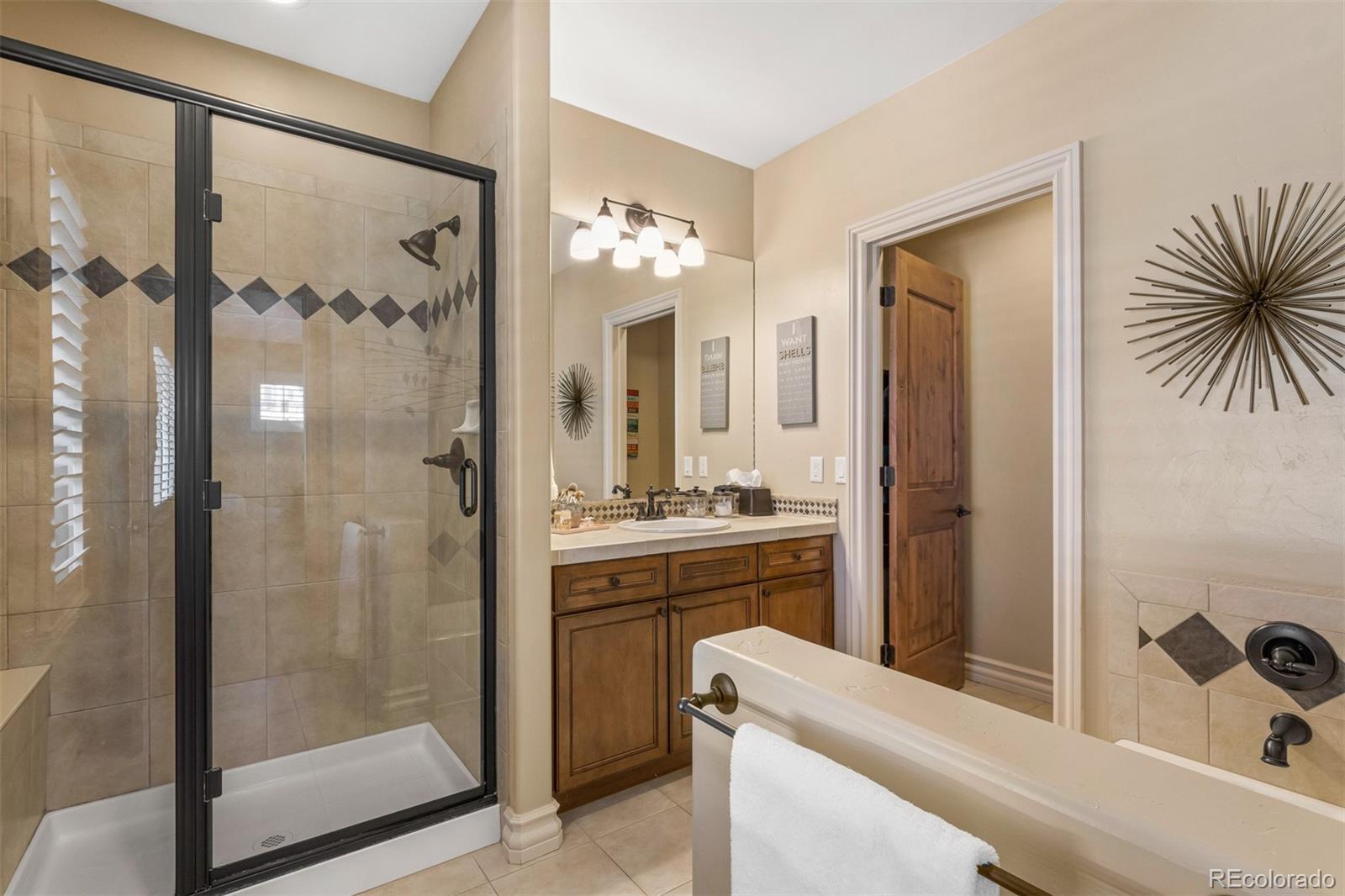981 Buffalo Ridge Road Castle Pines, CO 80108 - Photo 23 of 39 a bathroom with a tub a sink and mirrors