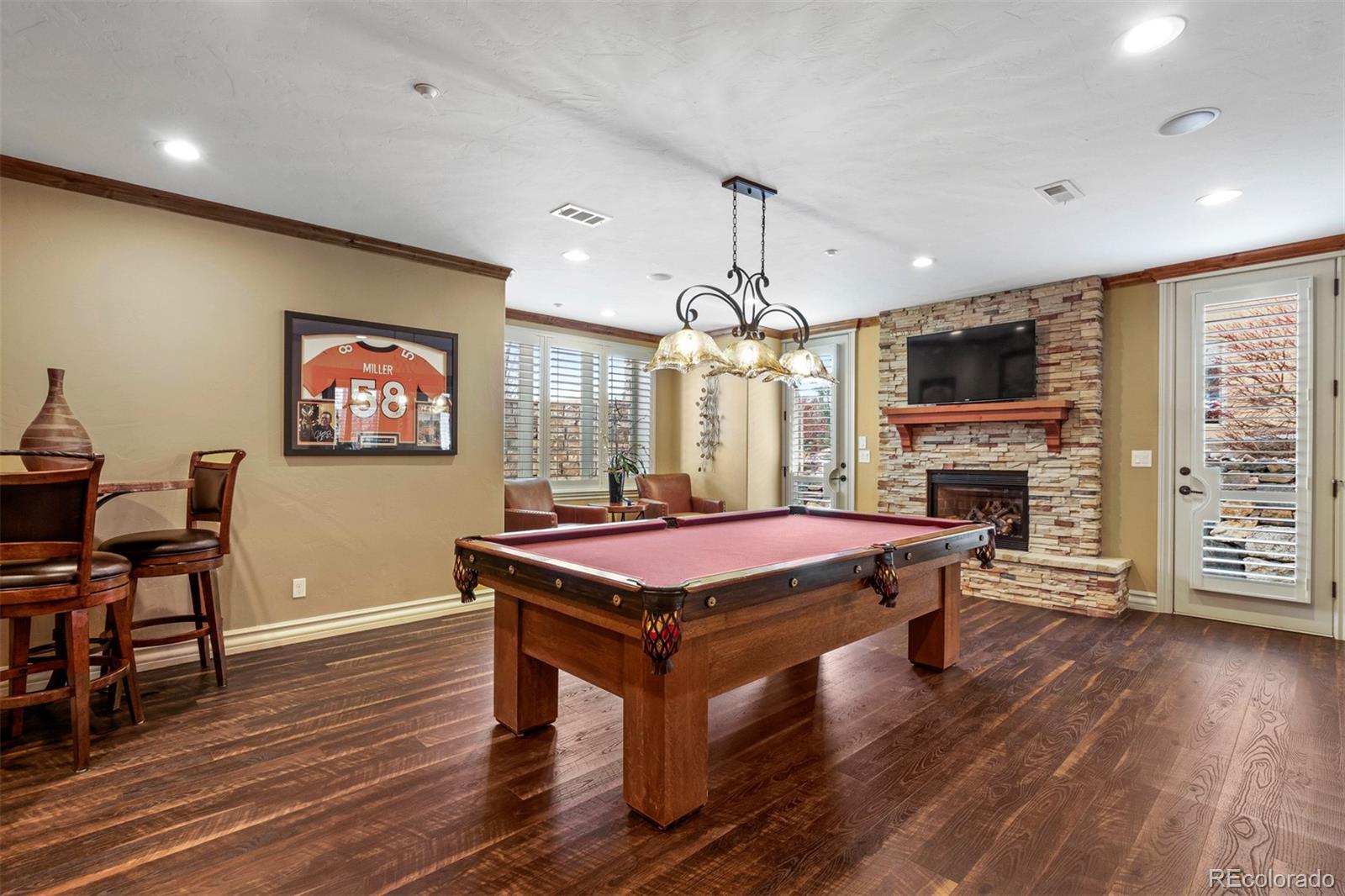 981 Buffalo Ridge Road Castle Pines, CO 80108 - Photo 27 of 39 a room with pool table flat screen tv and wooden floor