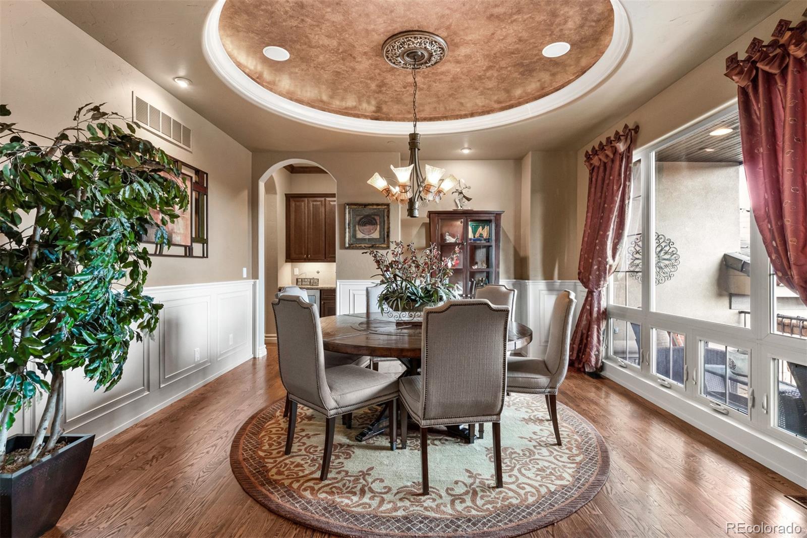 981 Buffalo Ridge Road Castle Pines, CO 80108 - Photo 9 of 39 a dining room with furniture a chandelier and wooden floor