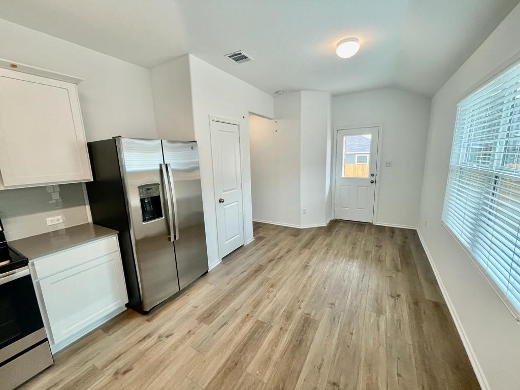 437 Perfect World Loop Jarrell, TX 76537 - Photo 5 of 17 a view of a kitchen with wooden floor and electronic appliances