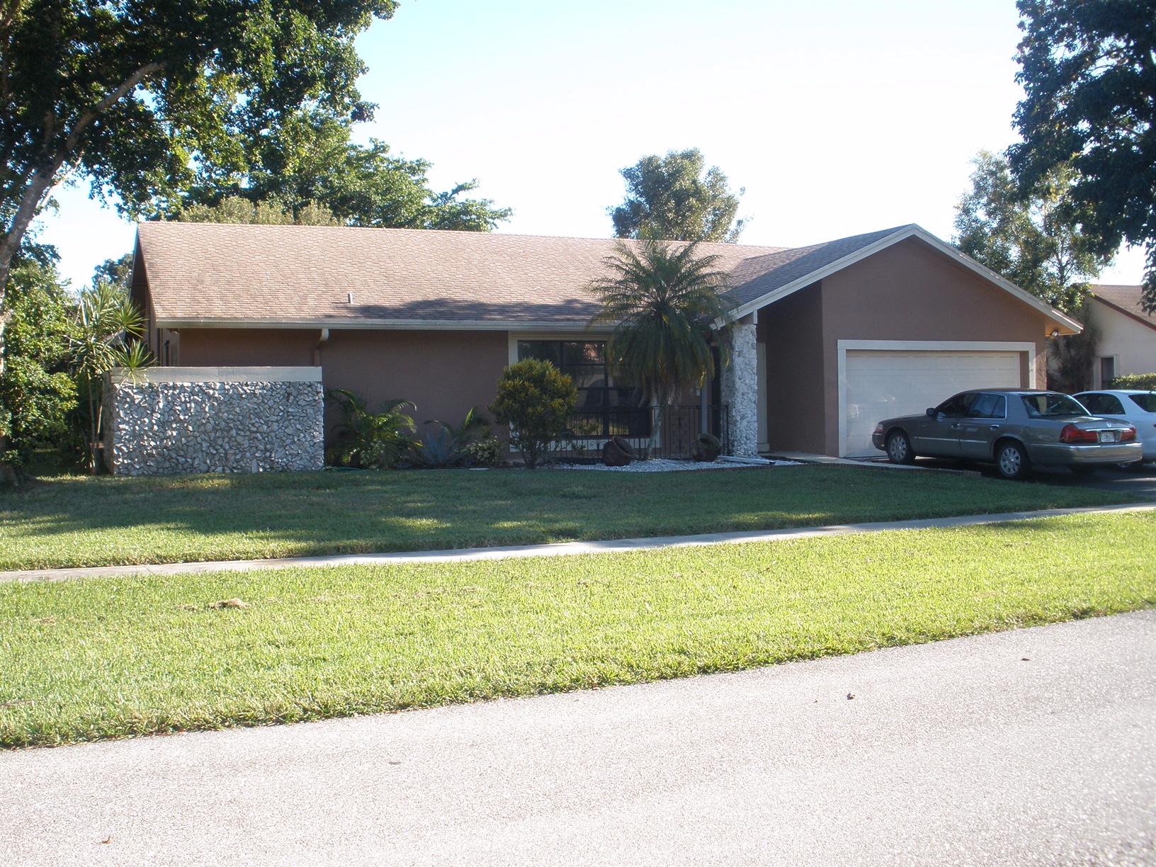 21293 Purple Sage Lane Boca Raton, FL 33428 - Photo 1 of 10 a front view of a house with a garden and yard