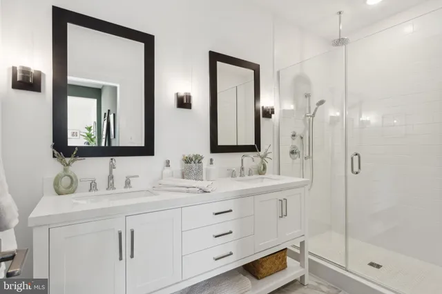 a bathroom with a double vanity sink mirror and shower