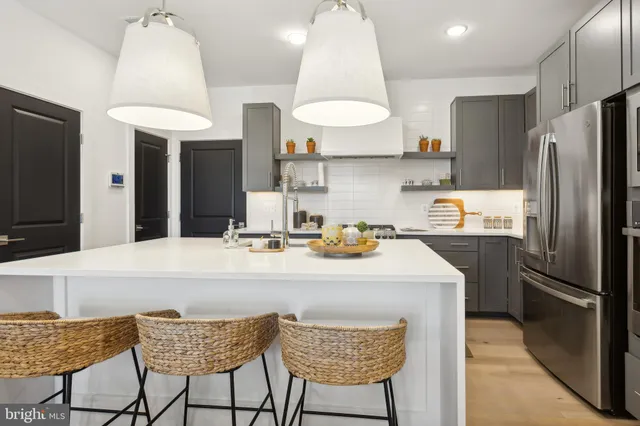 a kitchen with stainless steel appliances granite countertop a sink a stove a refrigerator and island