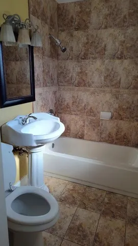 a bathroom with a sink toilet and mirror