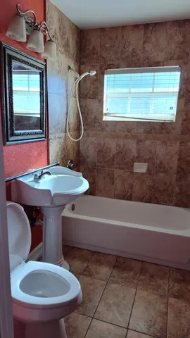a bathroom with a toilet a sink and bathtub