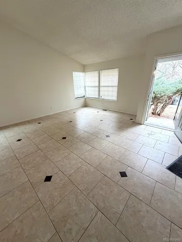 a view of empty room with window and outdoor seating
