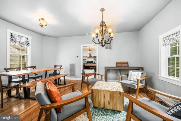 a living room with furniture a chandelier and a dining table