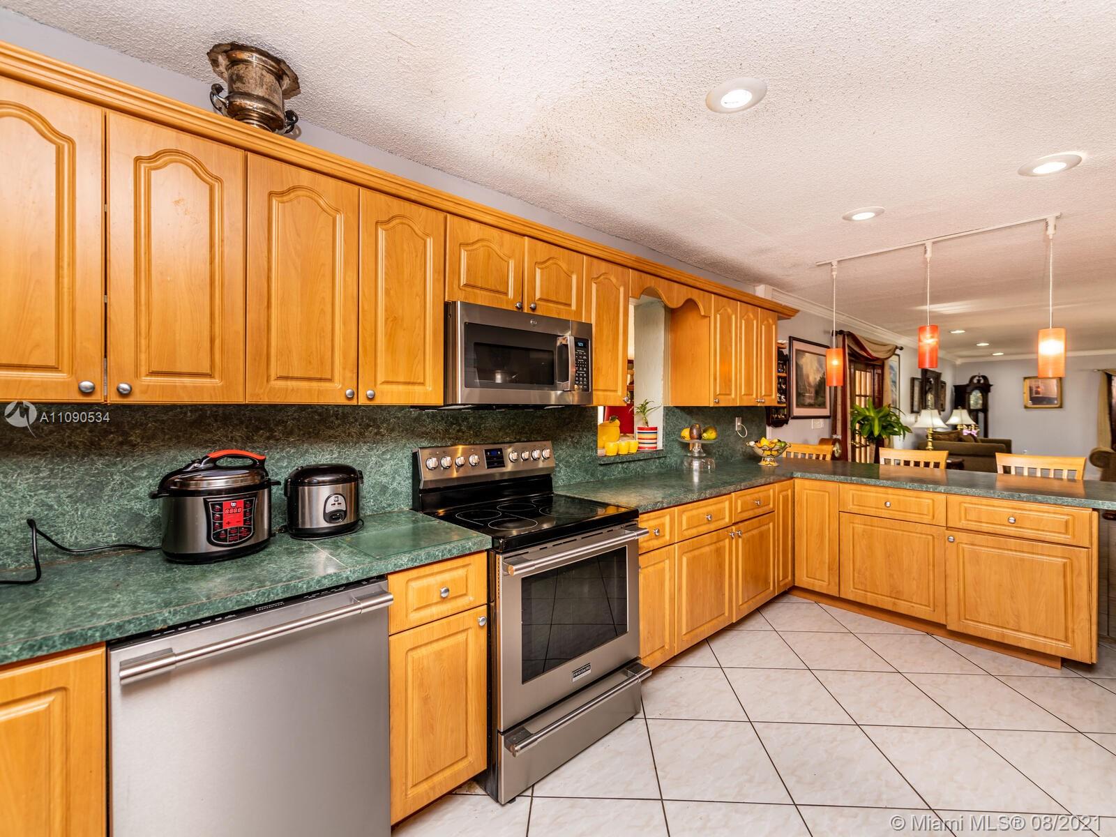 2820 Southwest 95th Avenue Miami, FL 33165 - Photo 33 of 100 a kitchen with stainless steel appliances granite countertop a stove top oven a sink dishwasher a dining table and chairs with wooden floor
