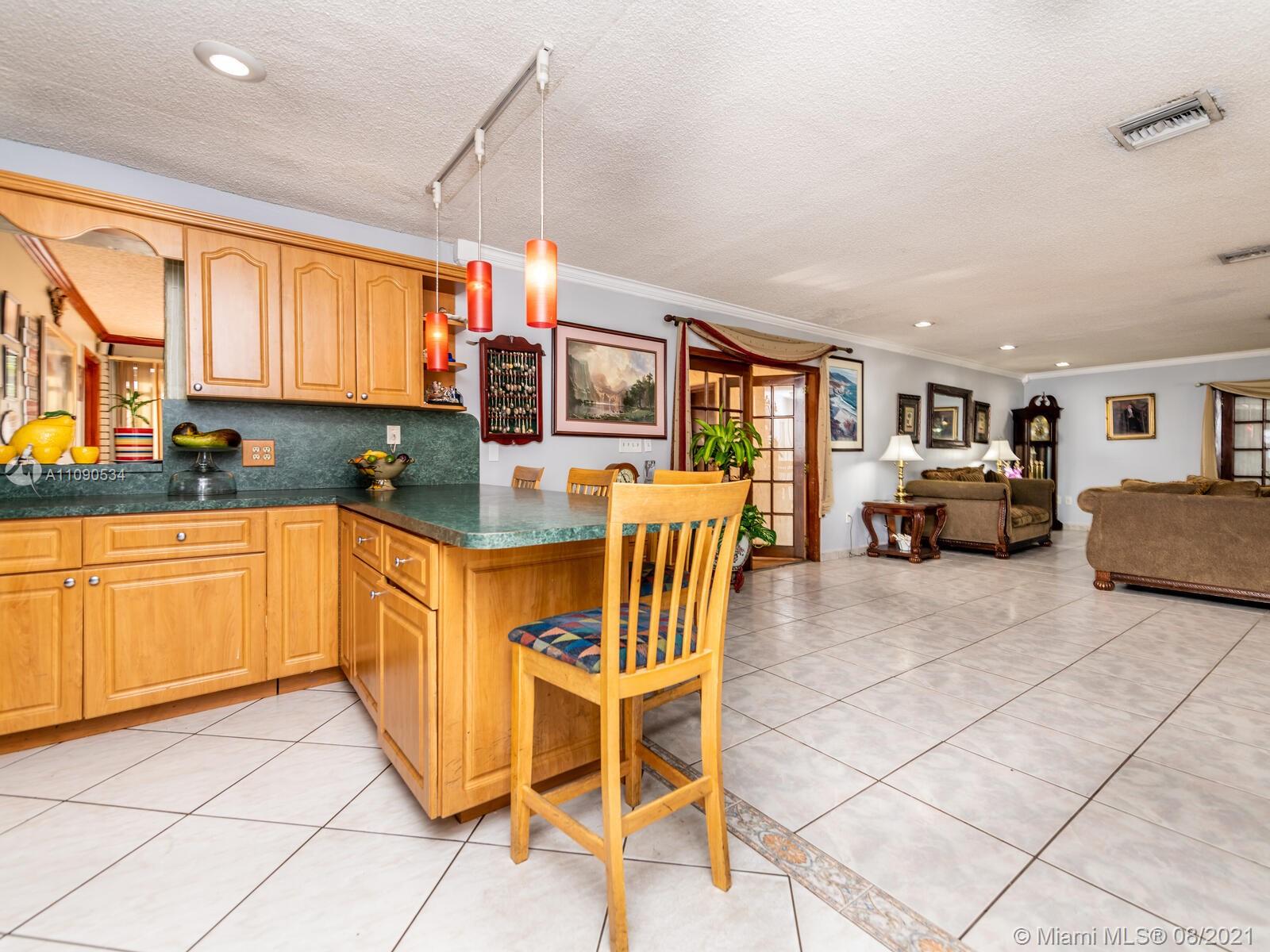 2820 Southwest 95th Avenue Miami, FL 33165 - Photo 35 of 100 a kitchen with stainless steel appliances granite countertop a stove top oven a sink dishwasher and white cabinets with wooden floor