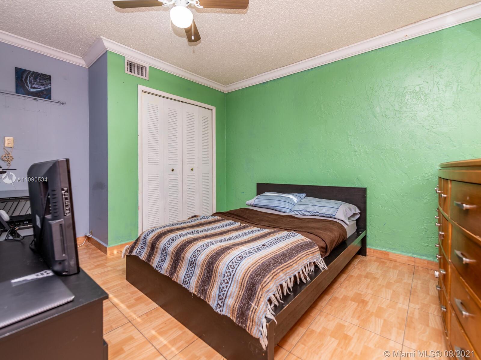 2820 Southwest 95th Avenue Miami, FL 33165 - Photo 50 of 100 a bedroom with a bed and a chandelier