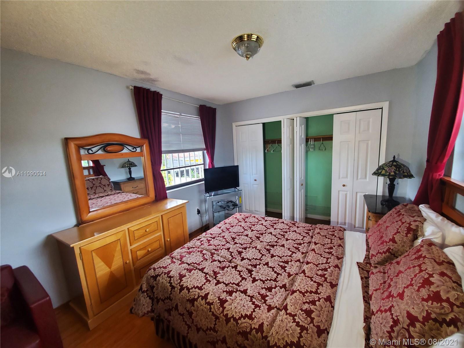 2820 Southwest 95th Avenue Miami, FL 33165 - Photo 100 of 100 a bedroom with a bed and dresser with wooden floor