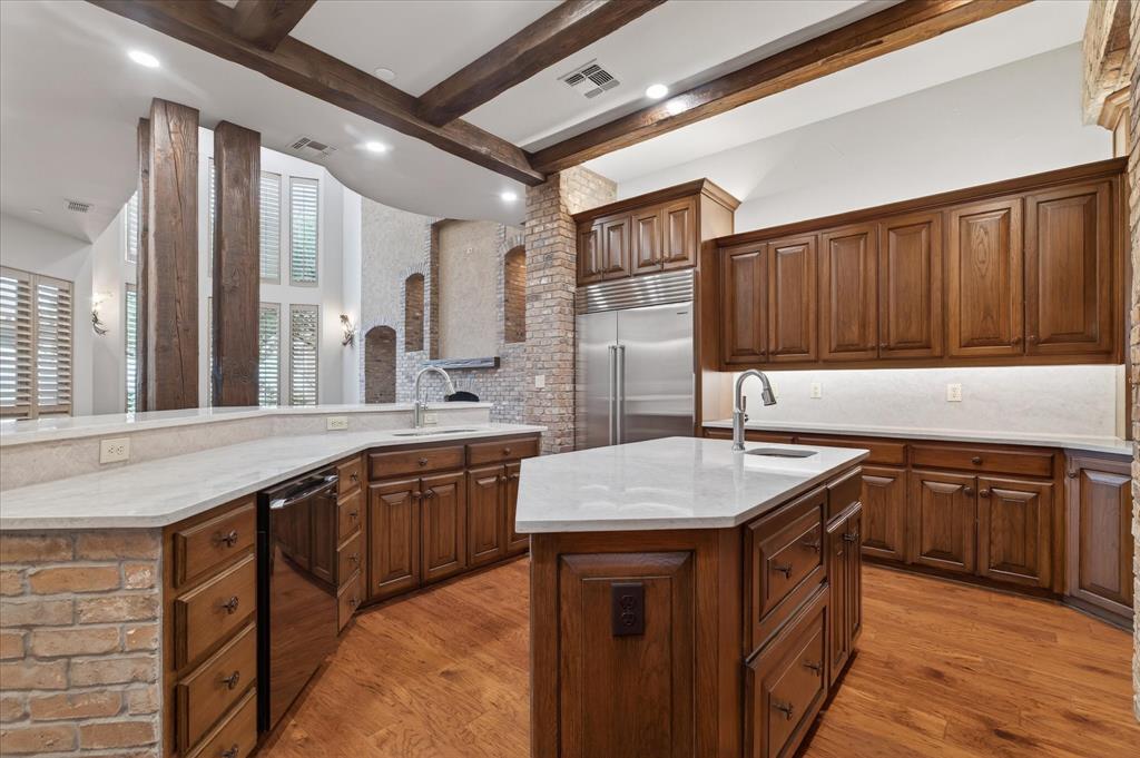 701 West Walcott Street Pilot Point, TX 76258 - Photo 13 of 40 Kitchen featuring beamed ceiling, light stone counters, built in refrigerator, dishwashing machine, and light wood-style flooring