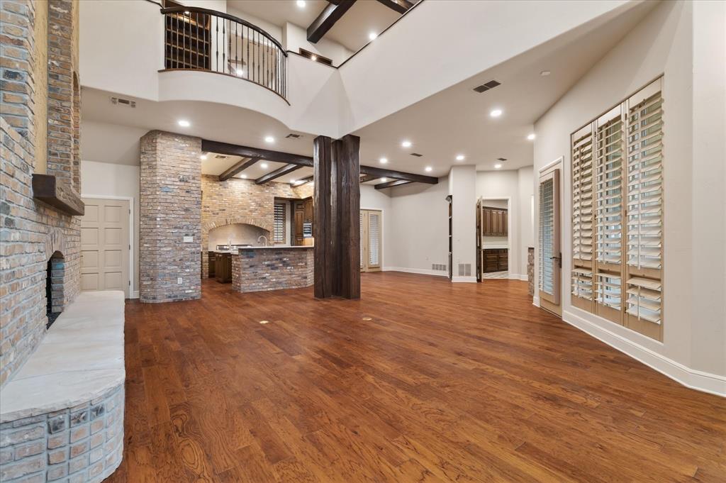 701 West Walcott Street Pilot Point, TX 76258 - Photo 19 of 40 Unfurnished living room featuring a brick fireplace, brick wall, dark wood-type flooring, and recessed lighting