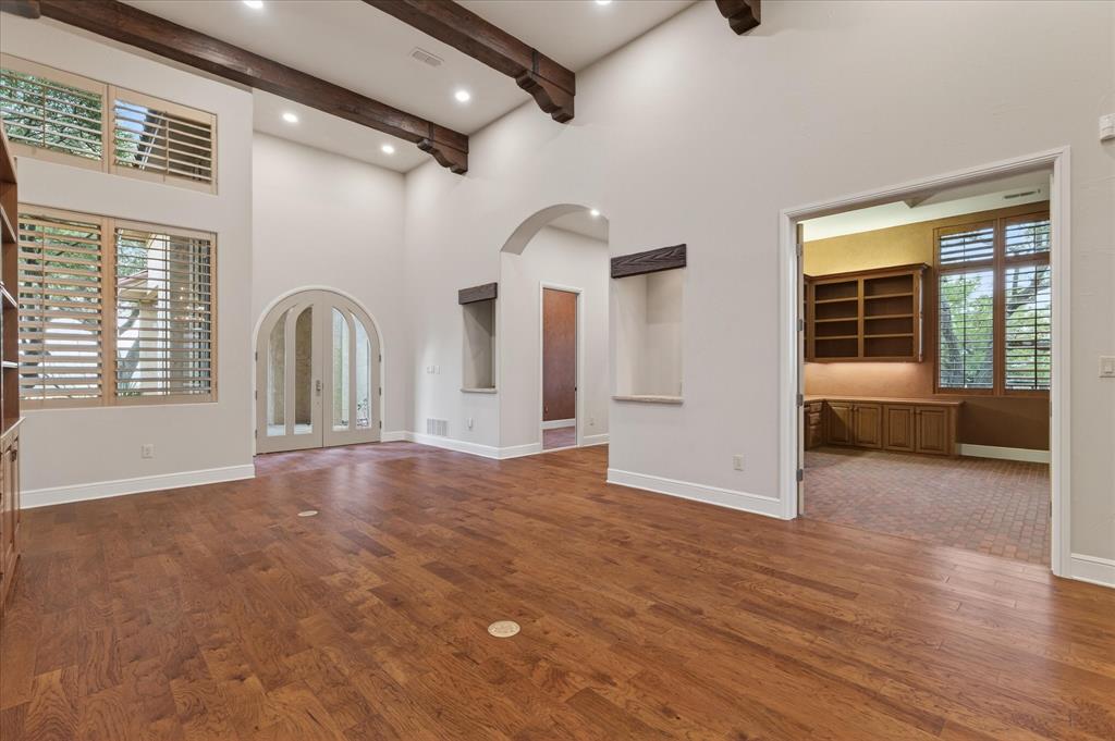 701 West Walcott Street Pilot Point, TX 76258 - Photo 30 of 40 Unfurnished living room with arched walkways, dark wood-type flooring, and french doors