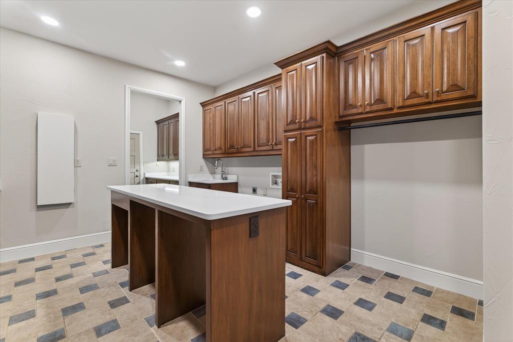 701 West Walcott Street Pilot Point, TX 76258 - Photo 38 of 40 Kitchen featuring light countertops, a kitchen island, wood finish cabinets, recessed lighting, and light floors