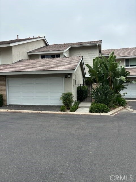 20 Brookmont, Unit 83 Irvine, CA 92604 - Photo 1 of 1 a front view of a house with a yard and garage