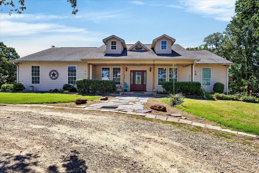 11591 Farm To Market 59 Athens, TX 75751 - Photo 2 of 40 Ranch-style residence featuring a covered front porch with natural wood columns, a red entry door, multiple dormer windows, and a flagstone pathway
