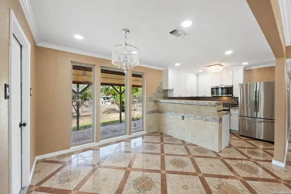 a kitchen with stainless steel appliances granite countertop a refrigerator and a stove top oven