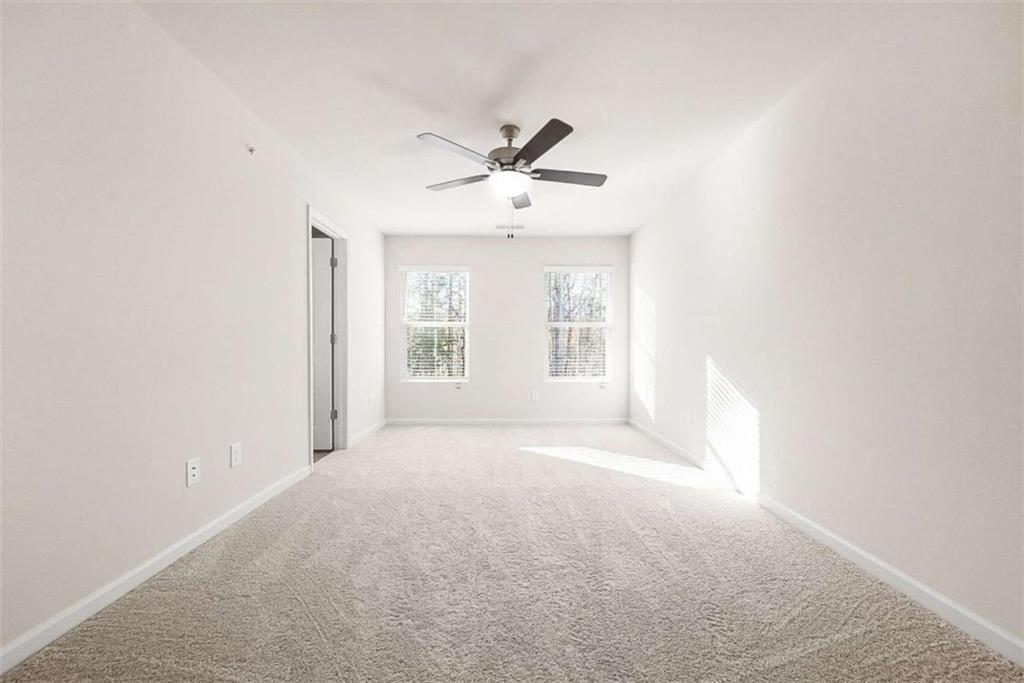 1328 Riverstone Road Jonesboro, GA 30238 - Photo 12 of 26 an empty room with windows and ceiling fan