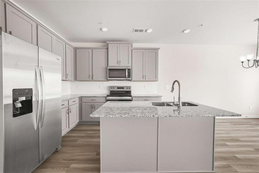 1328 Riverstone Road Jonesboro, GA 30238 - Photo 5 of 26 a kitchen with kitchen island granite countertop a sink stainless steel appliances and white cabinets