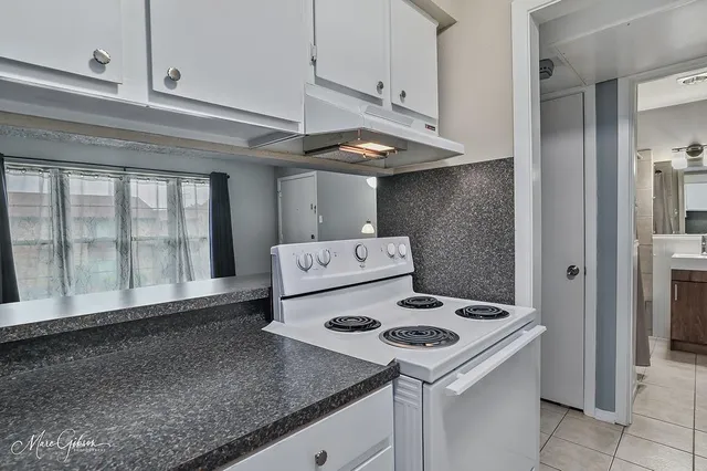 a kitchen with a stove cabinets and a counter top space