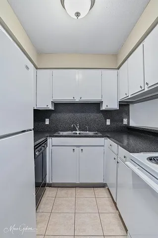 a kitchen with granite countertop a sink a stove and cabinets