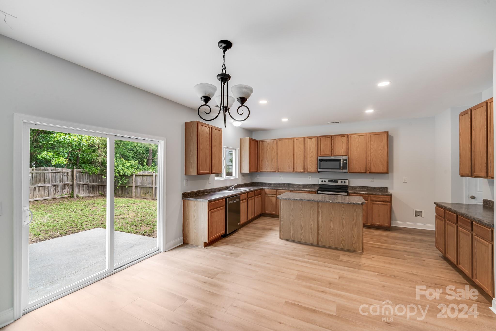 4420 Red Hook Road Monroe, NC 28110 - Photo 12 of 34 a large kitchen with stainless steel appliances granite countertop a stove and a wooden floors