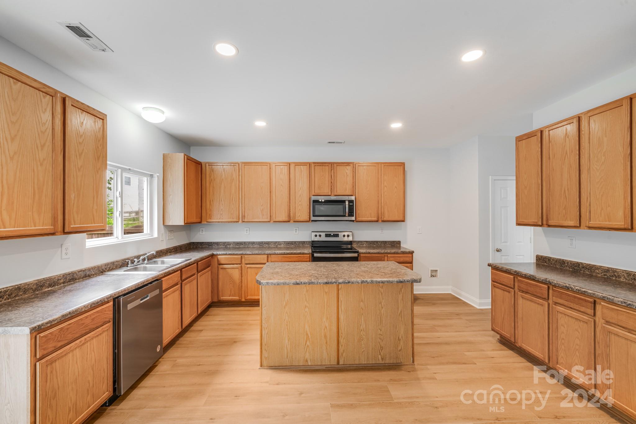 4420 Red Hook Road Monroe, NC 28110 - Photo 13 of 34 a large kitchen with stainless steel appliances granite countertop a stove a sink dishwasher and a microwave oven with cabinets
