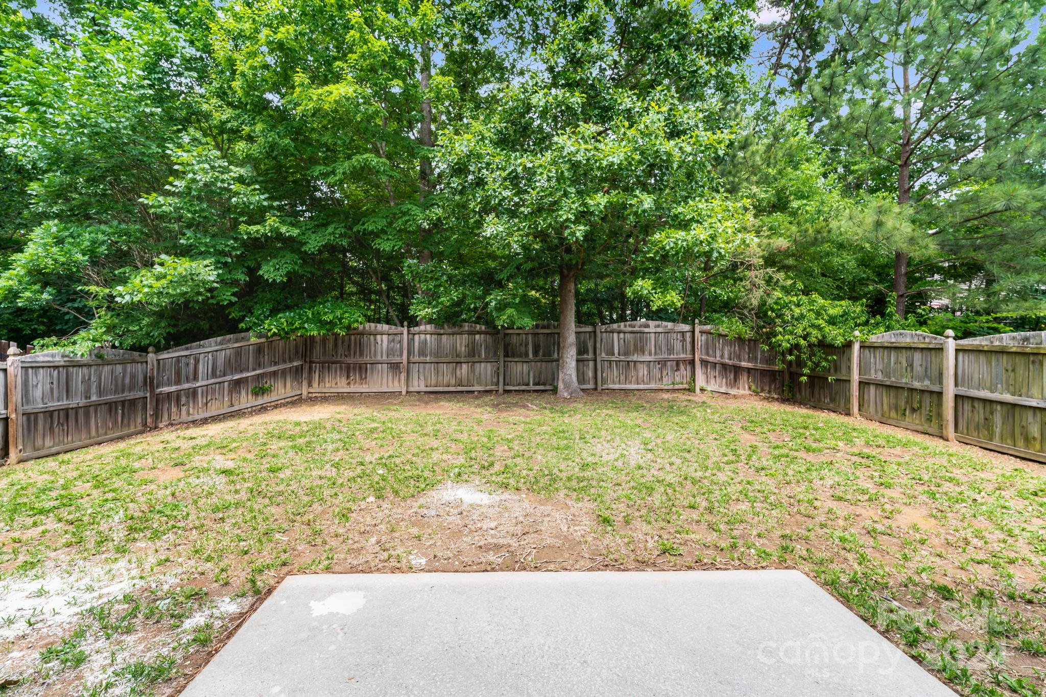 4420 Red Hook Road Monroe, NC 28110 - Photo 32 of 34 a backyard of a house with a large tree and wooden fence