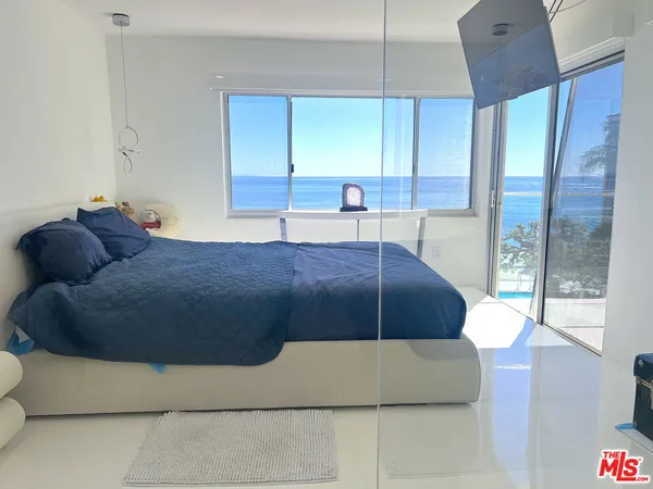 a living room with a bed furniture and next to a window