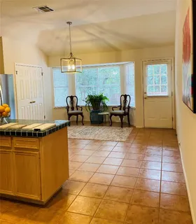 a living room with stainless steel appliances granite countertop a sink a counter top space and cabinets