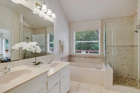 a bathroom with a bathtub a sink and a large mirror