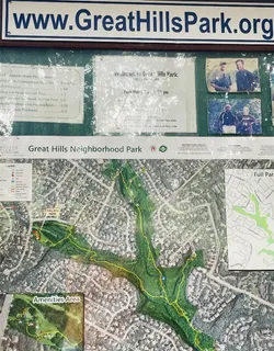 a sign of golf club on a wall under a tree