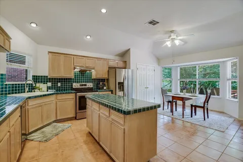 a kitchen with granite countertop cabinets a dining table and chairs