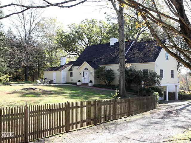 a view of a barn house next to a yard with wooden fence