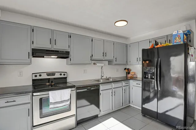 a kitchen with a sink a refrigerator and cabinets