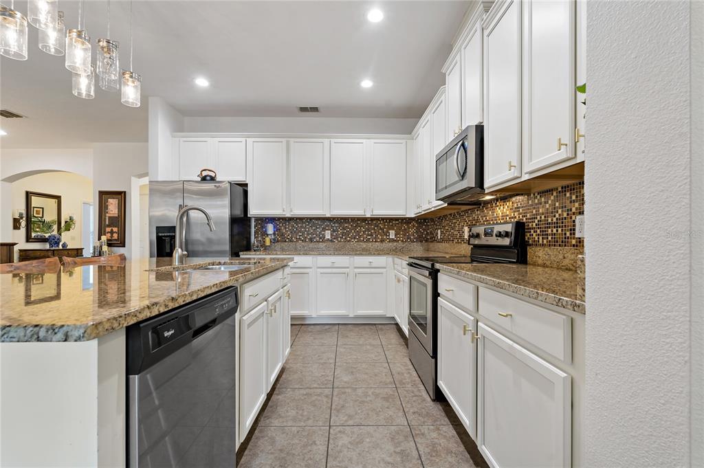178 Magneta Loop Auburndale, FL 33823 - Photo 13 of 77 a kitchen with stainless steel appliances granite countertop a sink and cabinets