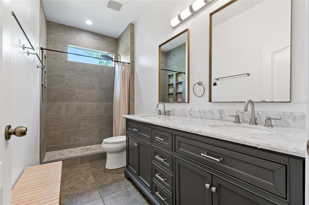 178 Magneta Loop Auburndale, FL 33823 - Photo 29 of 77 a bathroom with a double vanity sink toilet and shower