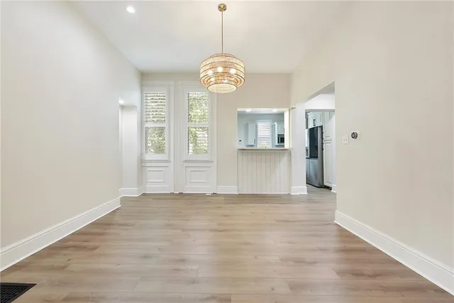 a view of an empty room with window and wooden floor